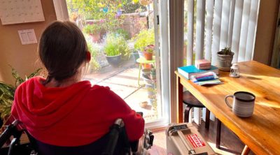 Josephine sitting in a wheelchair looking out the window reflecting on the trials and battle ahead.