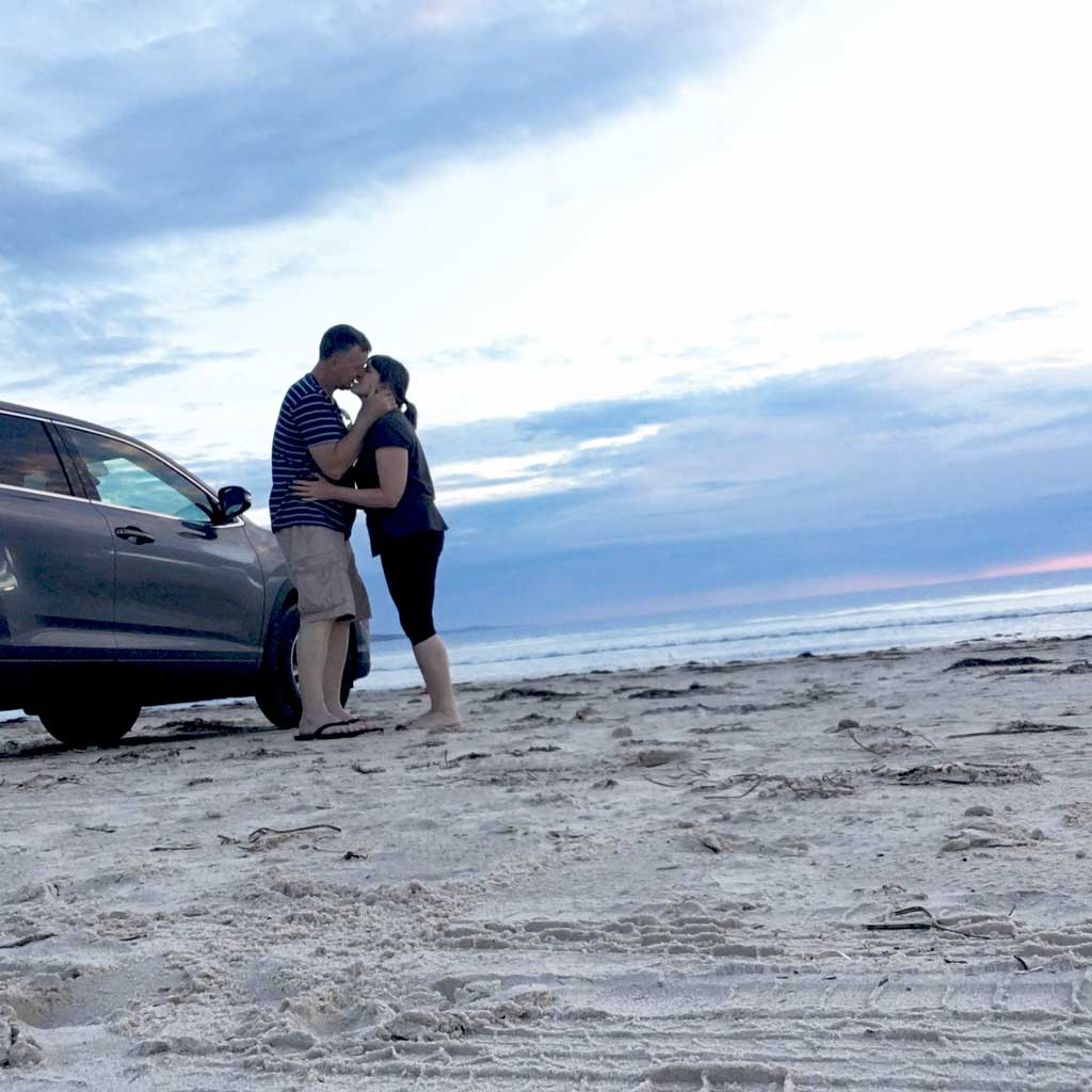 Josephine Mary Schmidt and her husband Leo Schmidt, kissing, standing and hugging on Aldinga Beach in South Australia.